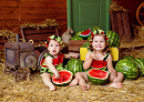 Crianças comendo melancias no celeiro