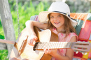 Menina bonito tocando guitarra