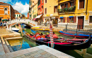 Canal estreito com um barco em Veneza, Itália