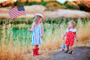 Duas meninas agitando a bandeira americana