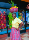Mulher jamaicana com cesta de frutas