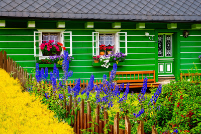 Fachada colorida da casa de campo e flores desabrochando