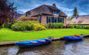 Casa à beira-mar e barcos a motor atracados, Giethoorn