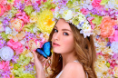 Jovem mulher na grinalda de flores com uma borboleta