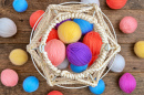 Cesta de tricô branca e novelas de fio coloridas